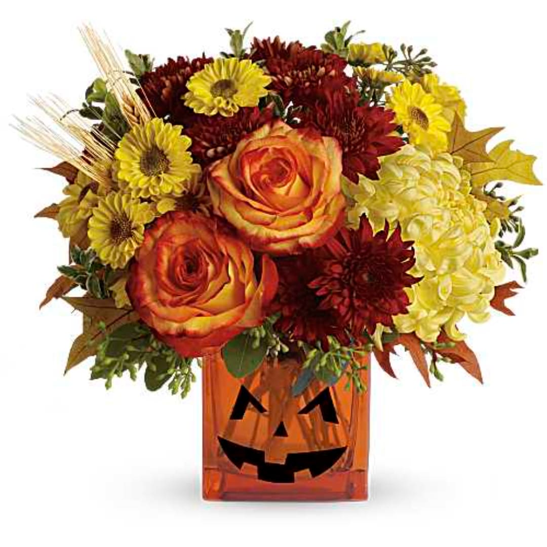 Autumn bouquet in a jack-o'-lantern vase with roses, mums, and sunflowers