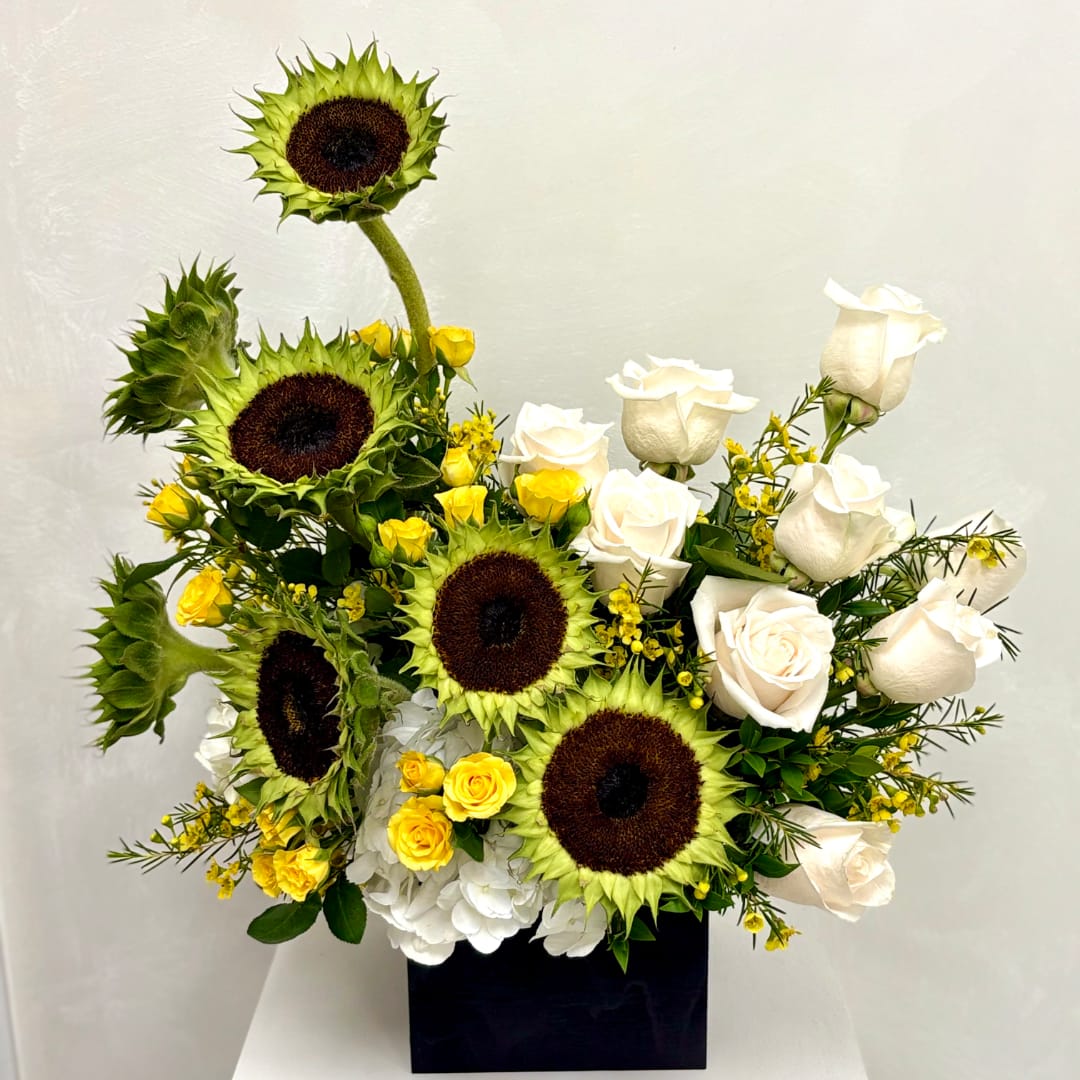 Sunflowers and white roses arranged in a black box