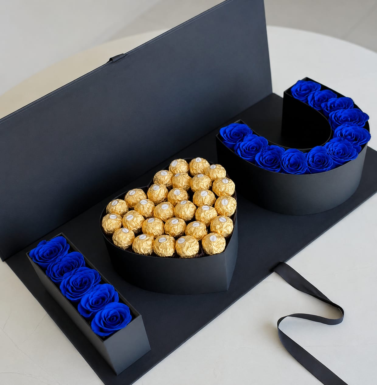 DAD Luxury Gift Box – Artificial Blue Roses &amp; Ferrero Collection - Celebrate Dad with a gift he can enjoy long after the special day. This luxury DAD-shaped gift box is crafted with stunning artificial blue roses and filled with delicious Ferrero Rocher chocolates, creating a unique and elegant presentation.  Unlike fresh flowers, the roses in this arrangement are artificial flowers, allowing the design to maintain its beauty over time with no maintenance required. The modern black box adds a sophisticated touch, making it perfect for Father’s Day, birthdays, anniversaries, or any occasion where you want to make a lasting impression.  Product Features: • Artificial blue roses (not fresh flowers) • Ferrero Rocher chocolates included • Premium black luxury gift box • Long-lasting decorative keepsake • Perfect for Father’s Day and special celebrations  Please Note: This arrangement contains artificial roses and is designed as a long-lasting decorative gift. 