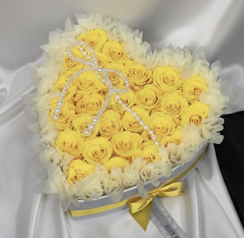 Eternal Sunshine Yellow Heart – Preserved Roses - A radiant expression of joy, appreciation, and positivity.  Our Eternal Sunshine Yellow Heart features premium preserved roses in a vibrant yellow tone, beautifully arranged inside an elegant heart-shaped box with refined detailing and satin ribbon accents. The bright yellow shade symbolizes happiness, friendship, gratitude, and celebration.  Preserved roses maintain their natural beauty for months — even years — with proper care, making this arrangement a meaningful and lasting keepsake.  The delicate decorative detail enhances its elegant presentation, creating a design that feels warm, uplifting, and unforgettable.  Perfect for birthdays, congratulations, Women’s Day, Mother’s Day, graduations, or simply to brighten someone’s day.  Available in two sizes: • 16 Preserved Roses • 27 Preserved Roses  A luminous gift designed to bring smiles and lasting memories.