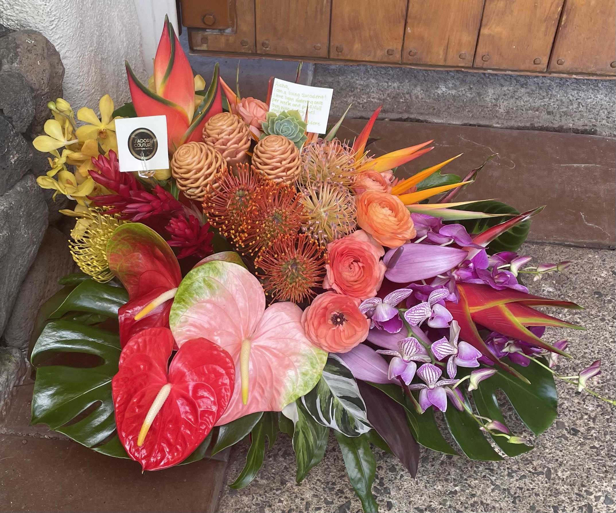 Tropical bouquet with anthuriums, orchids, and orange blooms