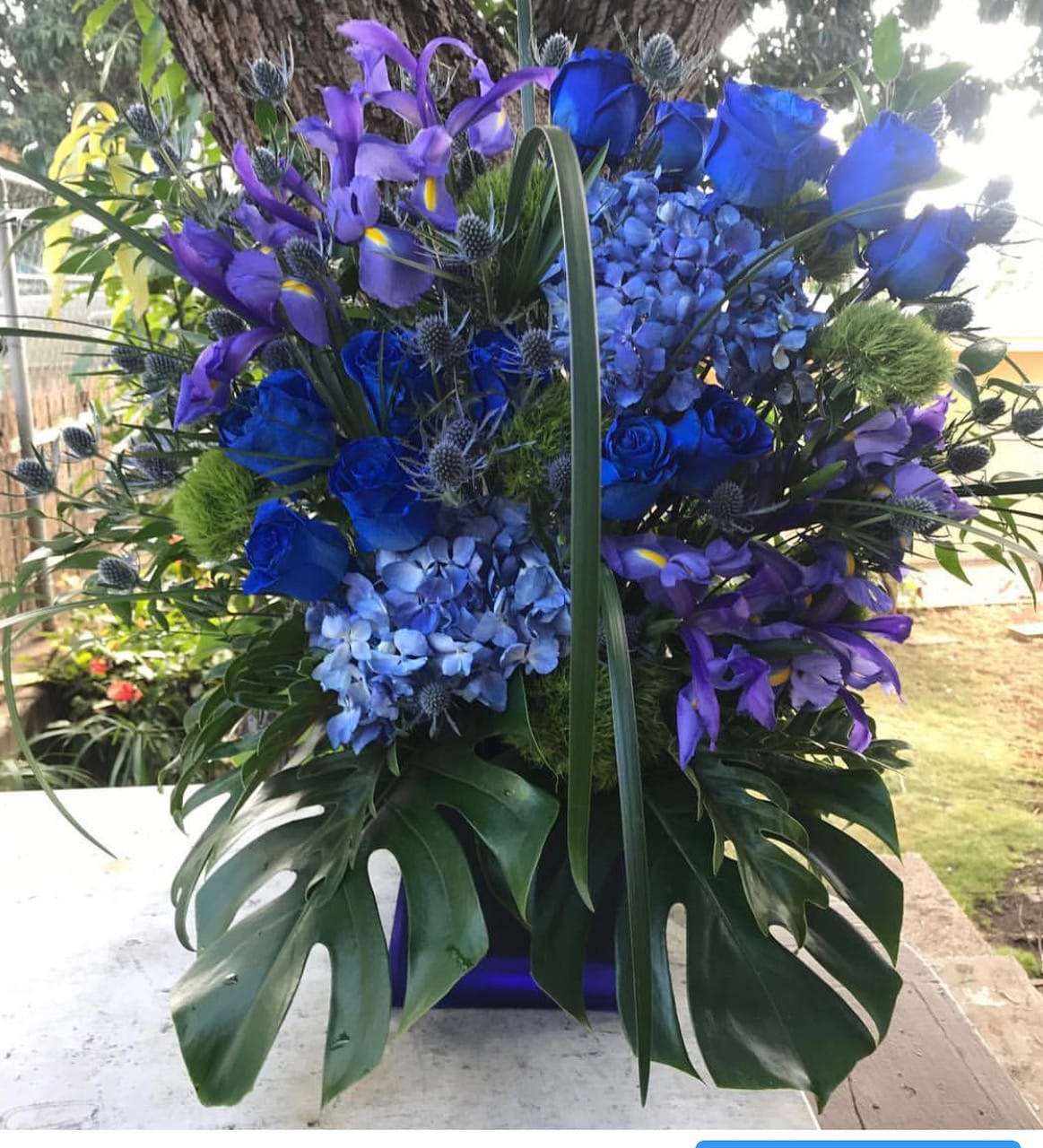 Blue and purple floral arrangement with roses, hydrangeas, and irises