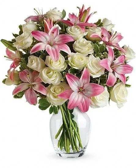 Pink lilies and white roses in a clear glass vase