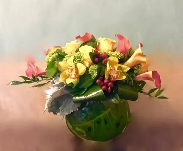 Bouquet of yellow roses and pink calla lilies in a green vase