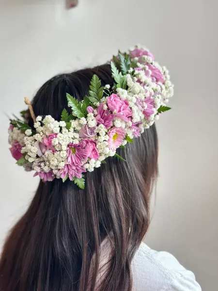 Pink and white flower crown worn on a person's head