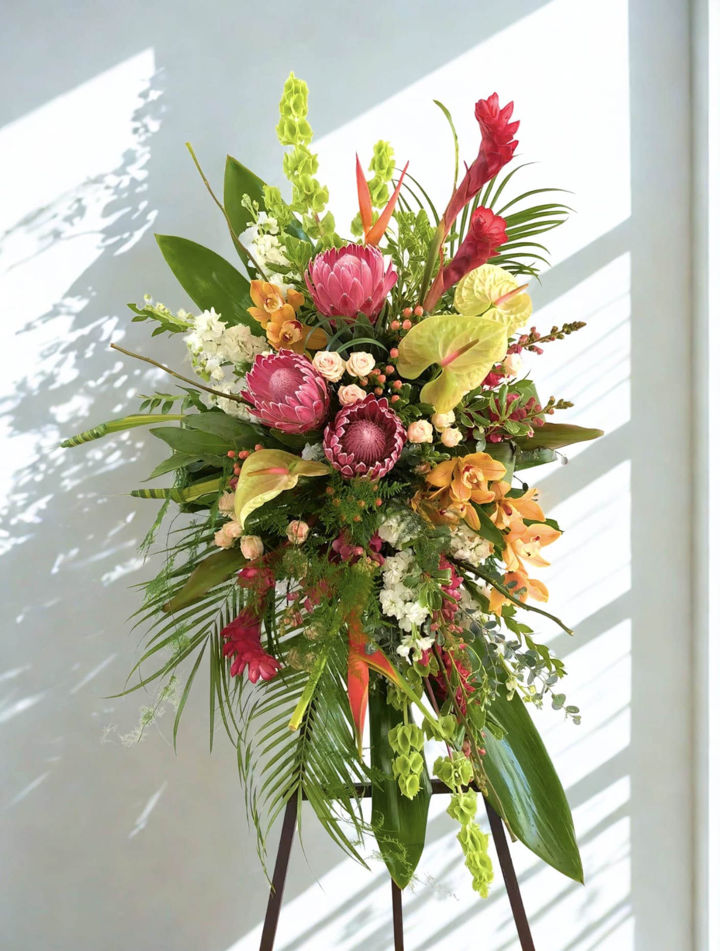 Tall tropical standing arrangement with pink and orange flowers