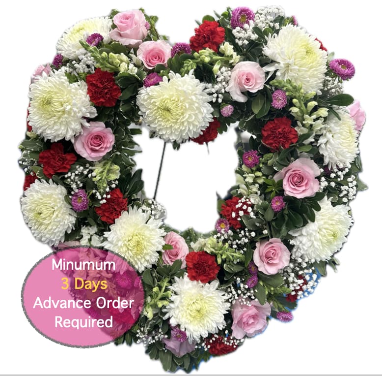 Heart-shaped floral wreath with pink roses, white mums, and red carnations
