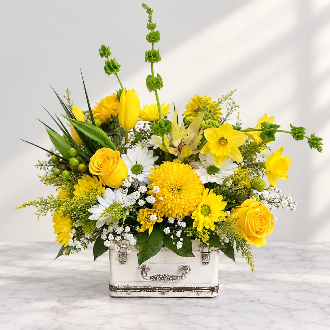Yellow and white flower arrangement in a white metal container