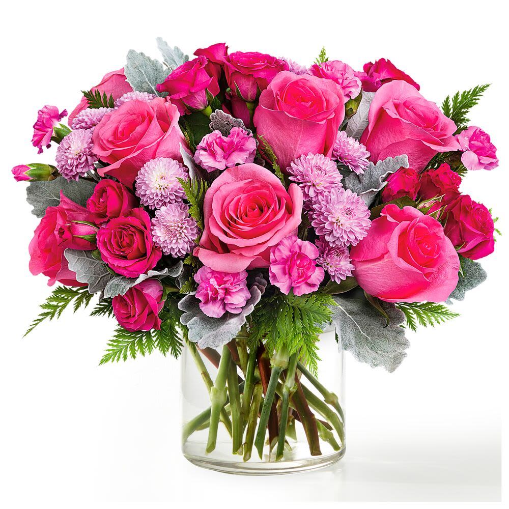 Pretty In Pink - Overflowing with vibrant shades of pink, this charming arrangement features lush roses accented with delicate spray roses, soft cushion mums, and textured greenery. Designed in a clear glass vase, it’s a fresh and feminine statement that brings warmth, joy, and a touch of elegance to any occasion.  Please note: Flower varieties may vary based on availability, but the overall look, feel, and color palette will be beautifully maintained.