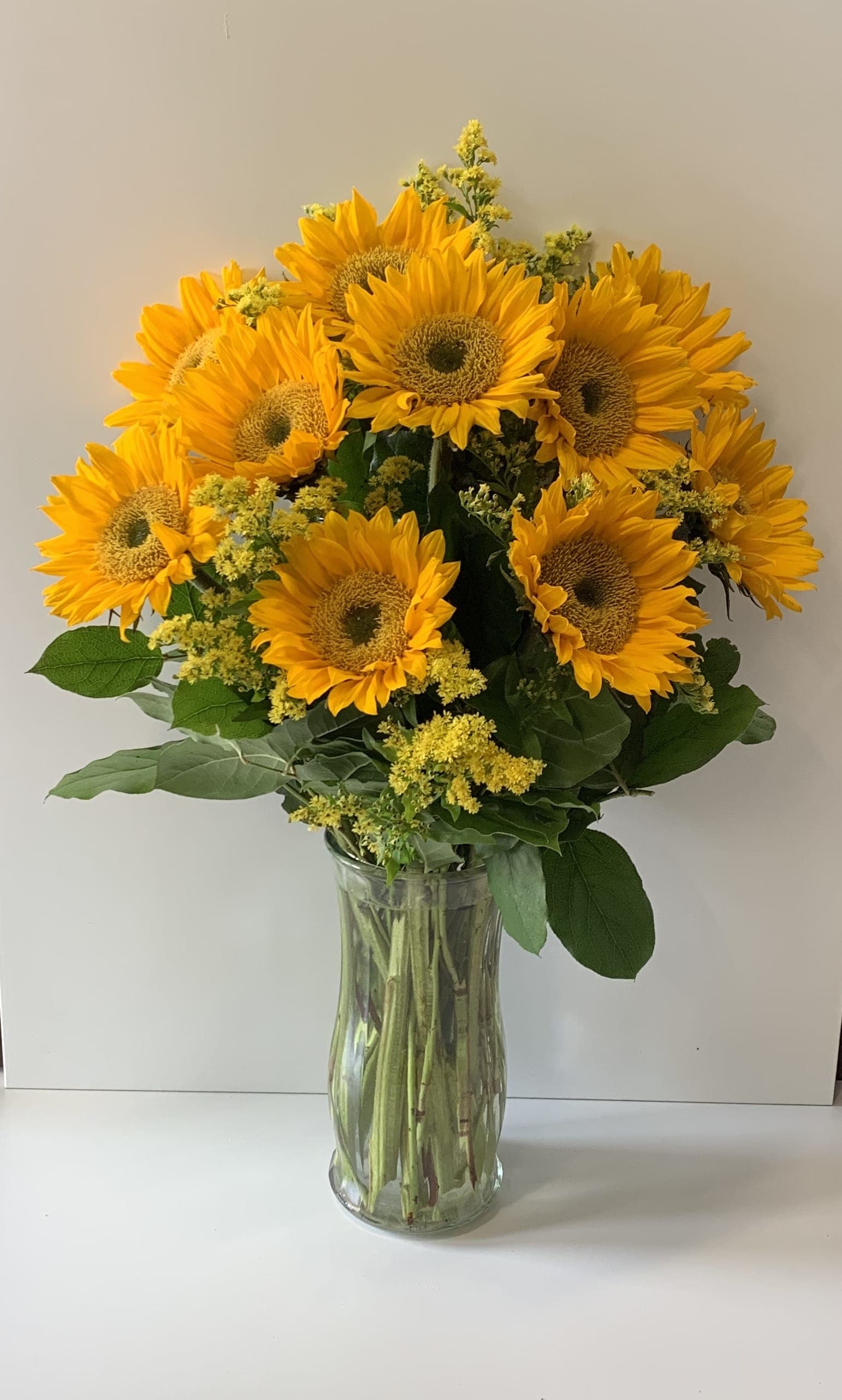 Bouquet of yellow sunflowers in a clear glass vase