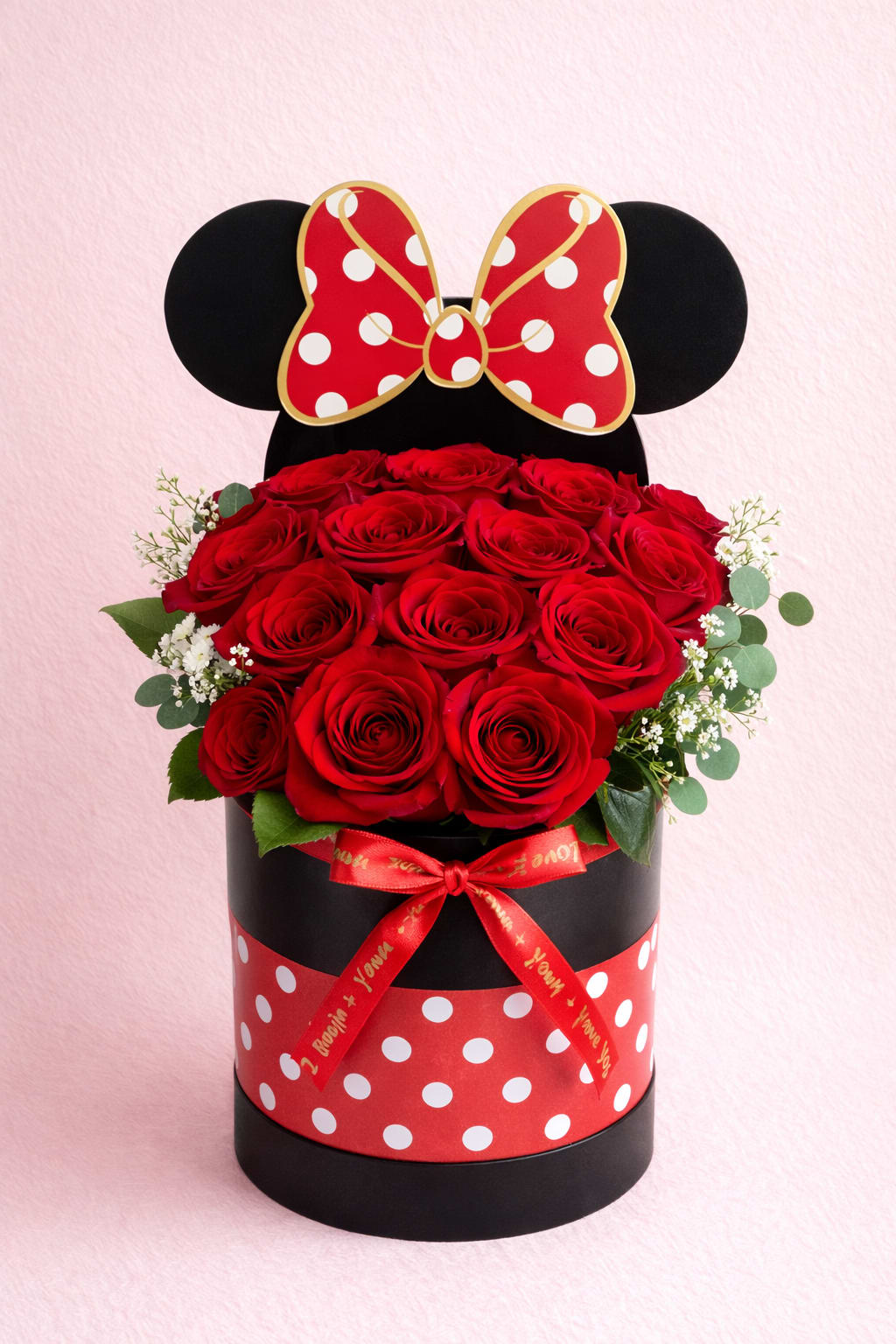 Red roses in a black round box with a Minnie Mouse bow topper