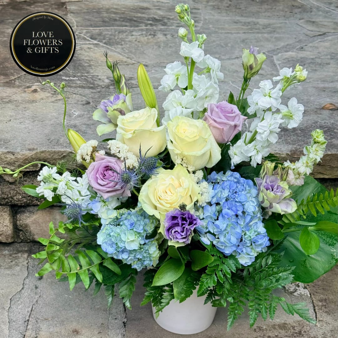 Pastel roses, hydrangeas, and white stock in a white vase
