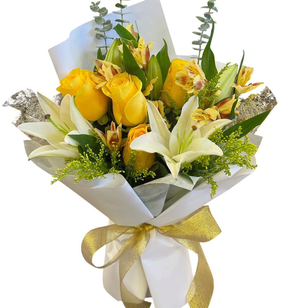 Yellow roses and white lilies in a wrapped bouquet with a gold ribbon