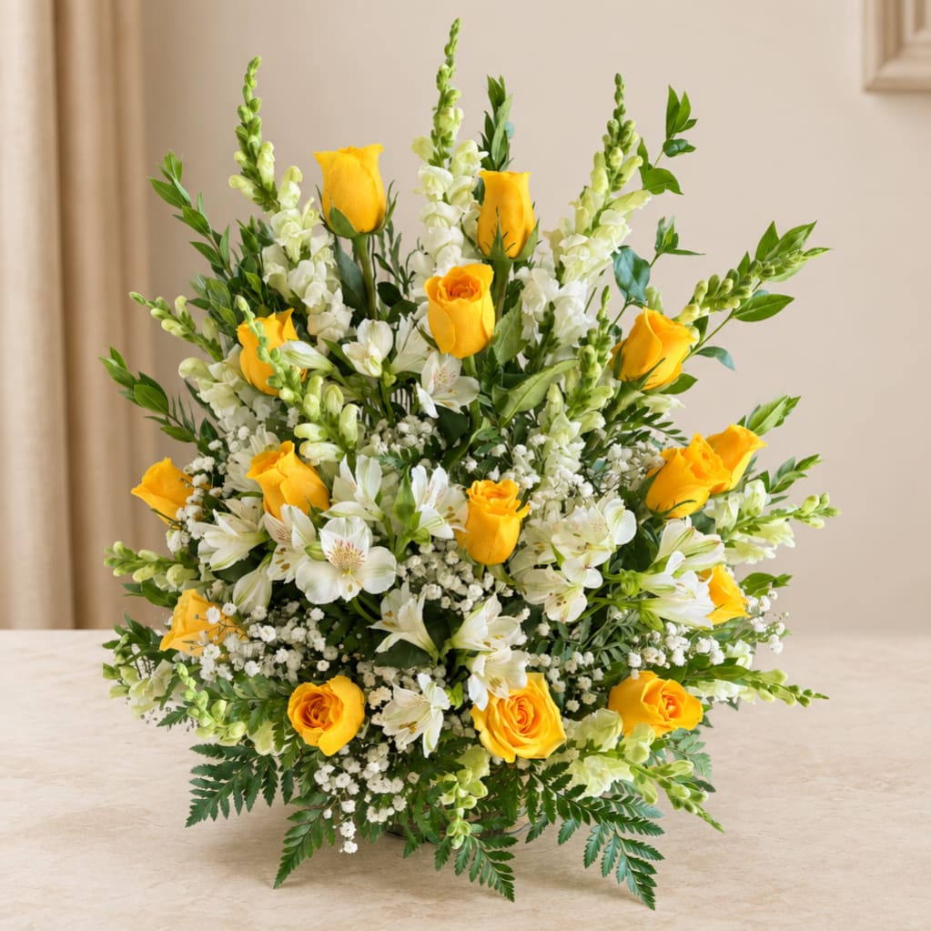 Yellow roses and white flowers arranged in a low vase