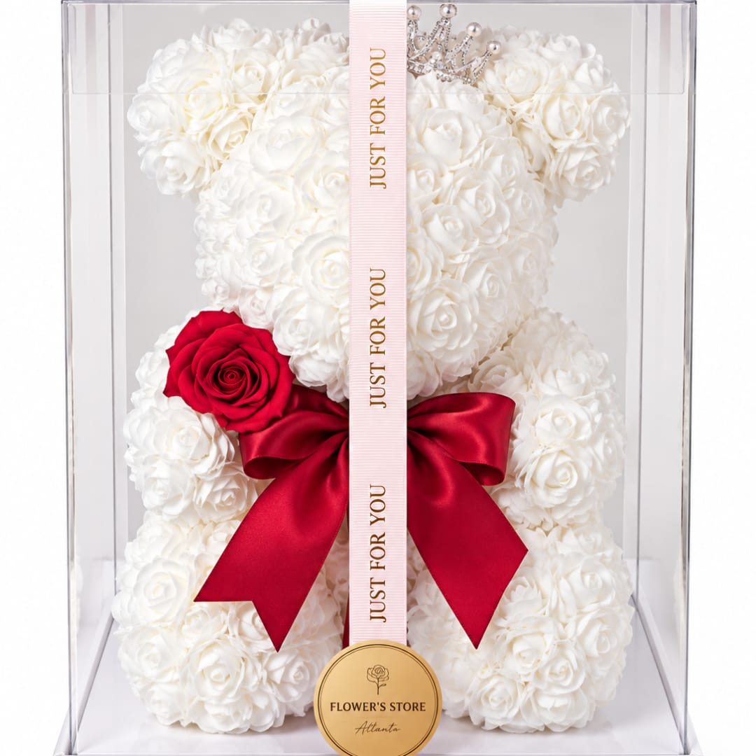 White rose teddy bear in a clear box with a red bow and ribbon