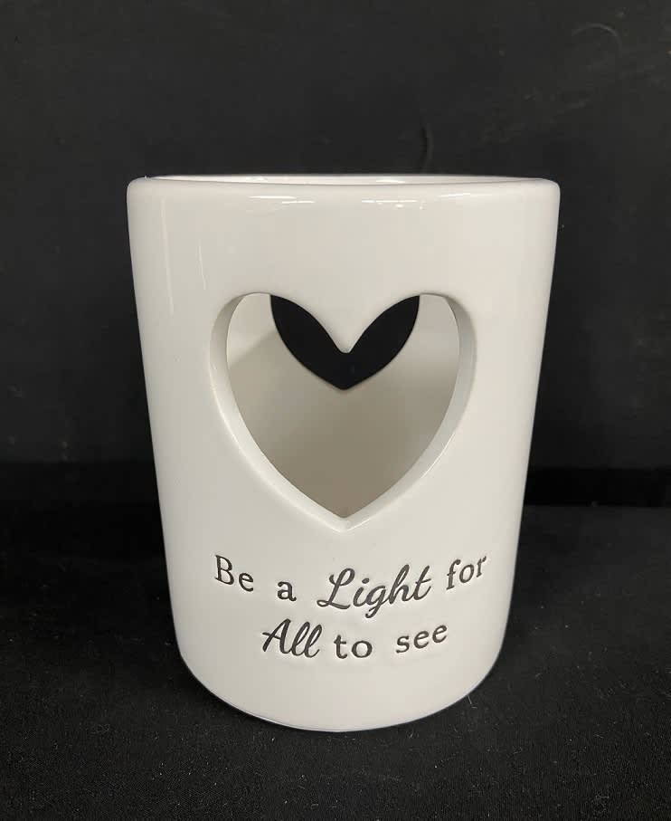 White ceramic candle holder with a heart cutout and printed text