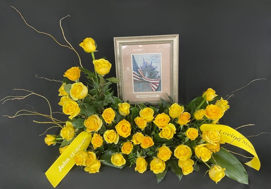 Yellow rose funeral spray with framed tribute and ribbons