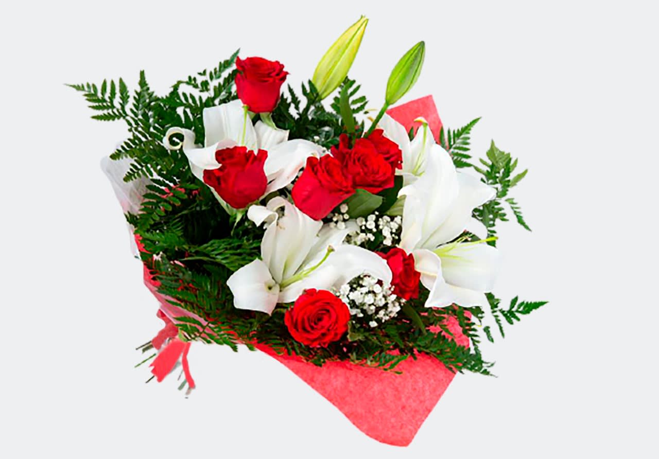 Bouquet of red roses and white lilies wrapped in pink paper