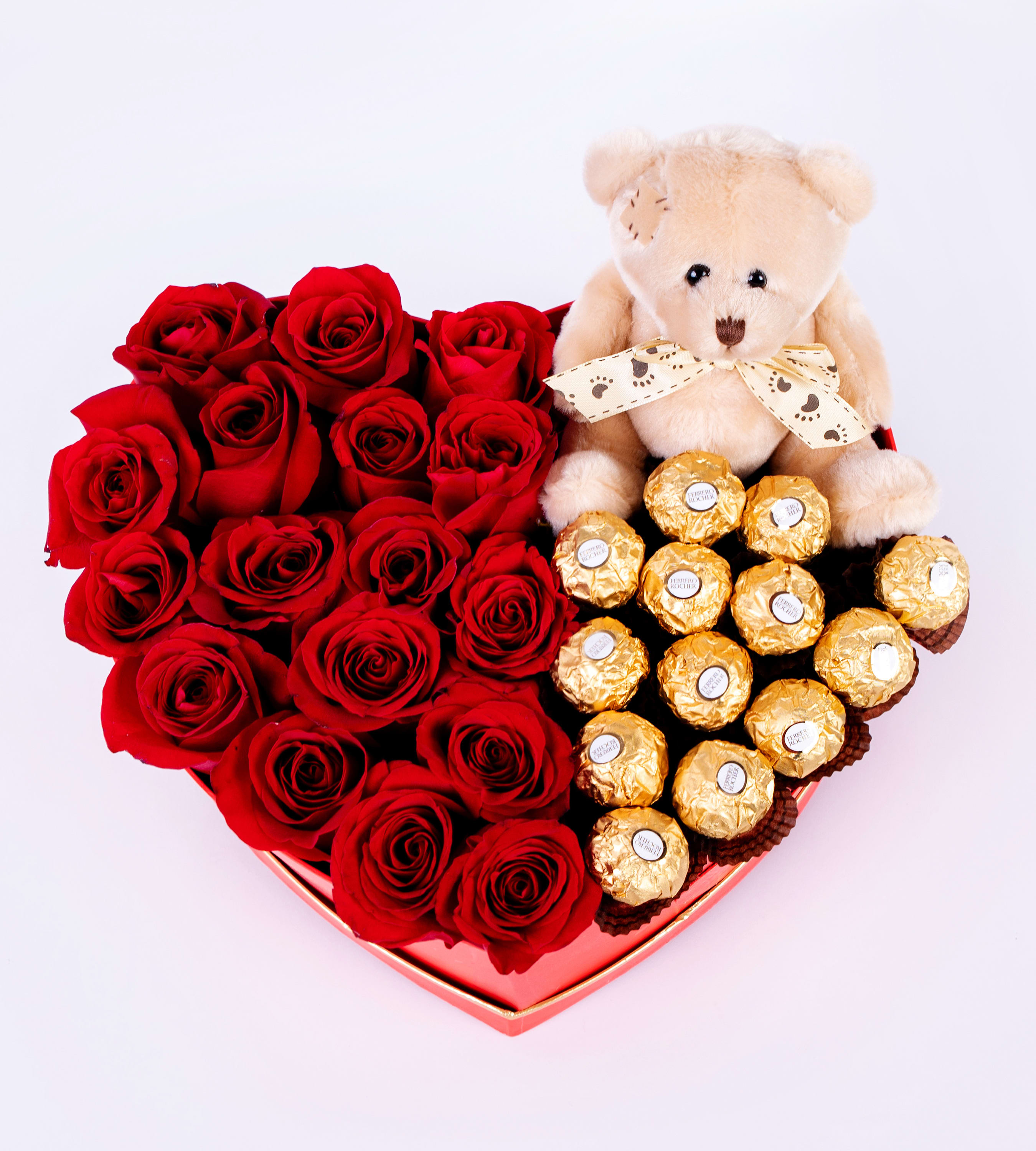 Heart-shaped box of red roses with a teddy bear and chocolates
