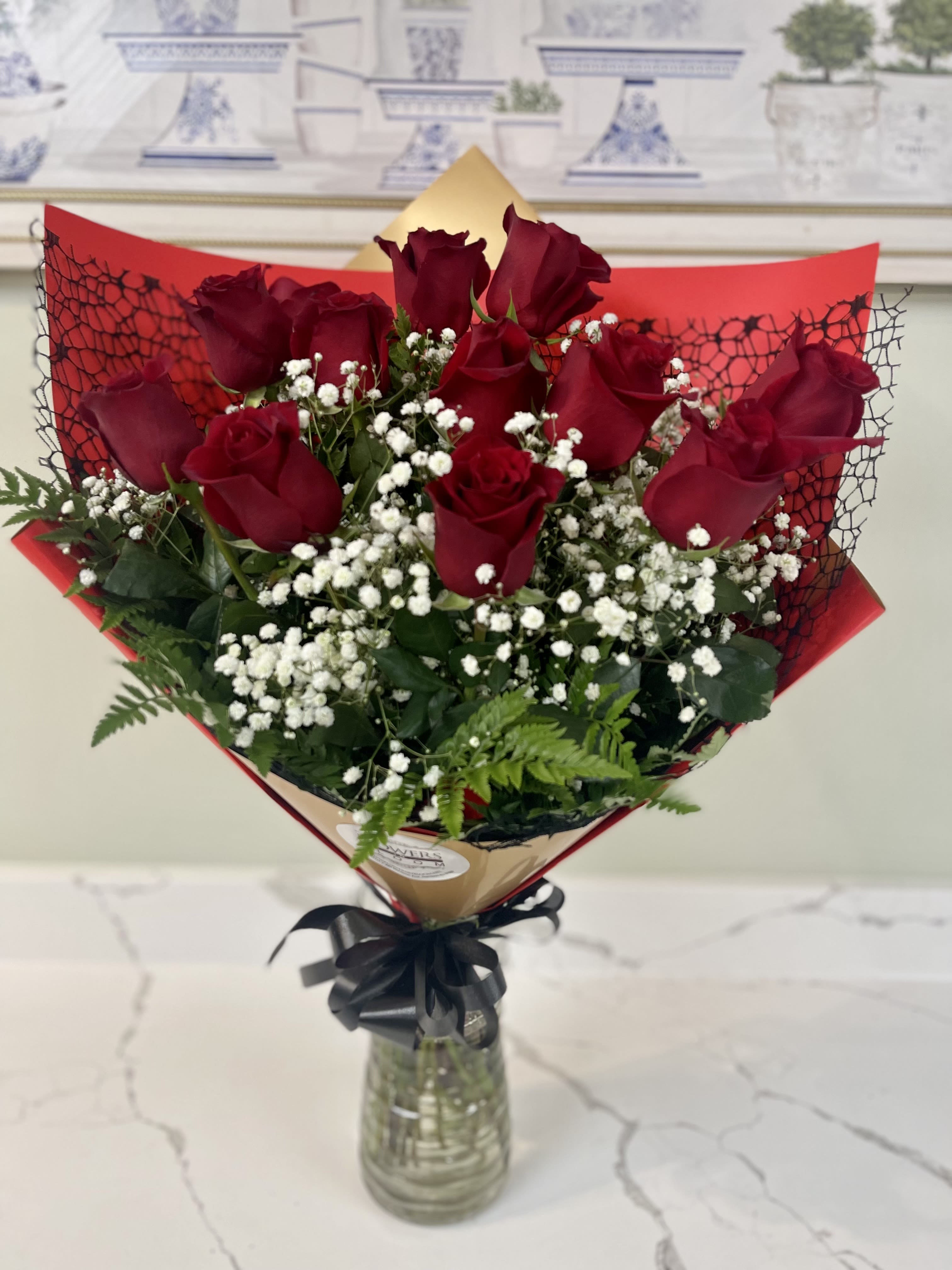 Bouquet of red roses and white baby's breath in a glass vase