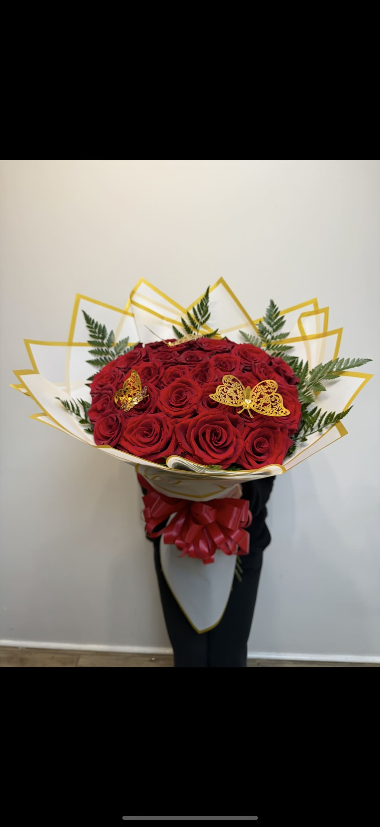 Bouquet of red roses with gold butterfly accents and white-gold wrapping