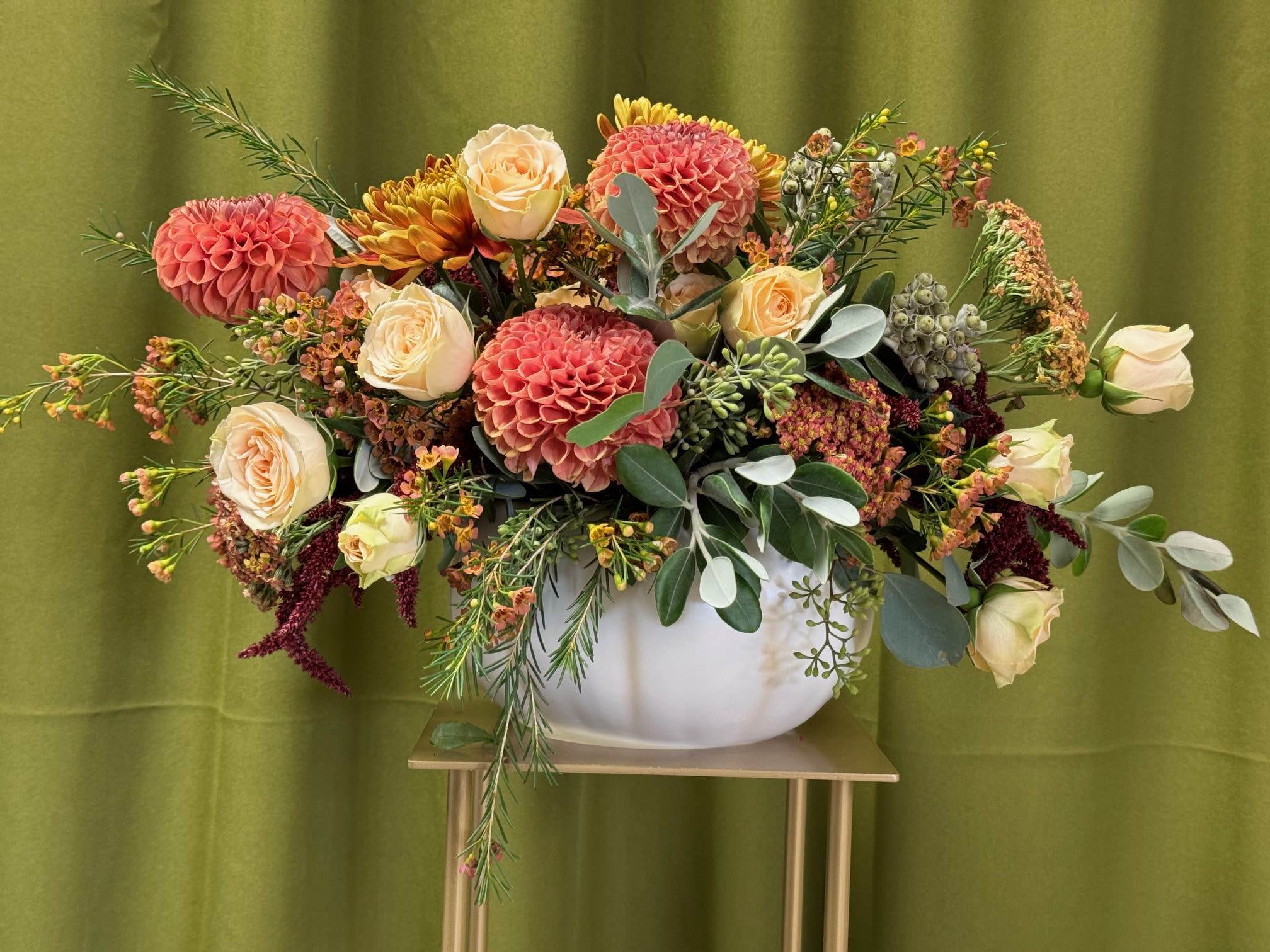 Mixed bouquet of pink dahlias and cream roses in a white vase
