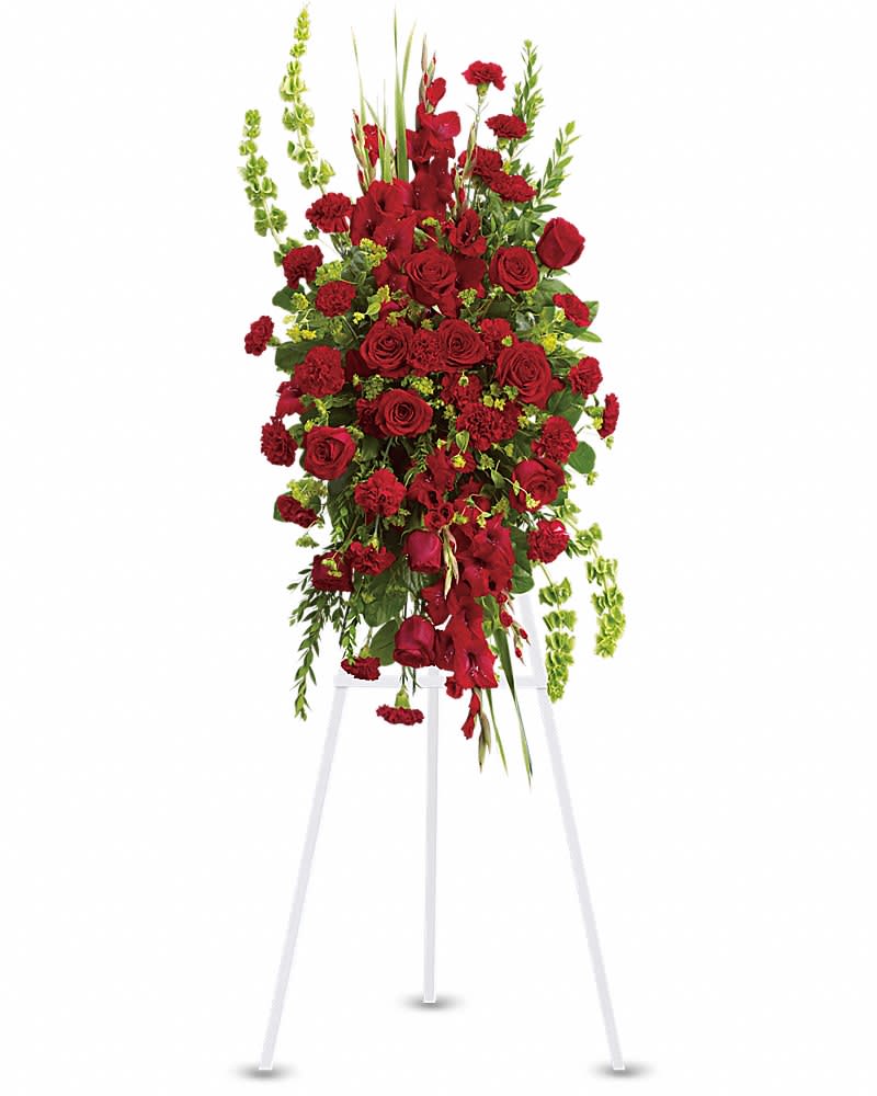 Tall red standing spray of roses and carnations with greenery on a white easel stand