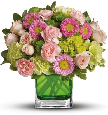 Pink and green mixed bouquet in a square glass vase