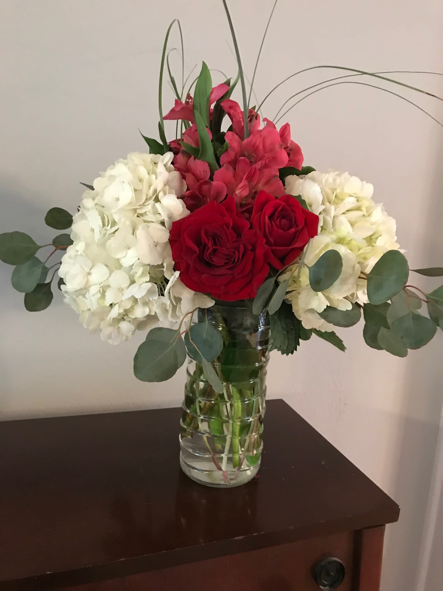 Red roses and white hydrangeas in a glass vase