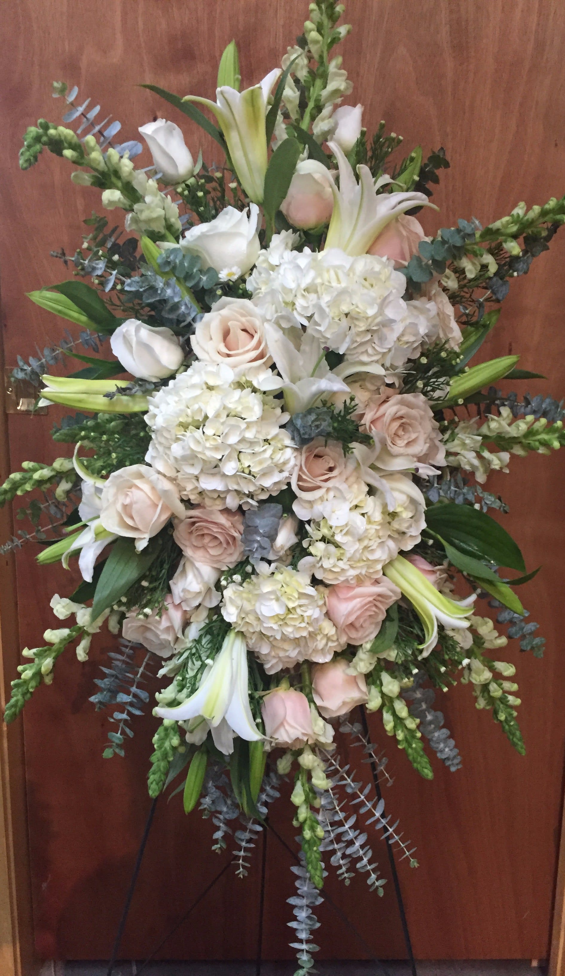 Large white and blush floral spray with lilies and roses on a stand