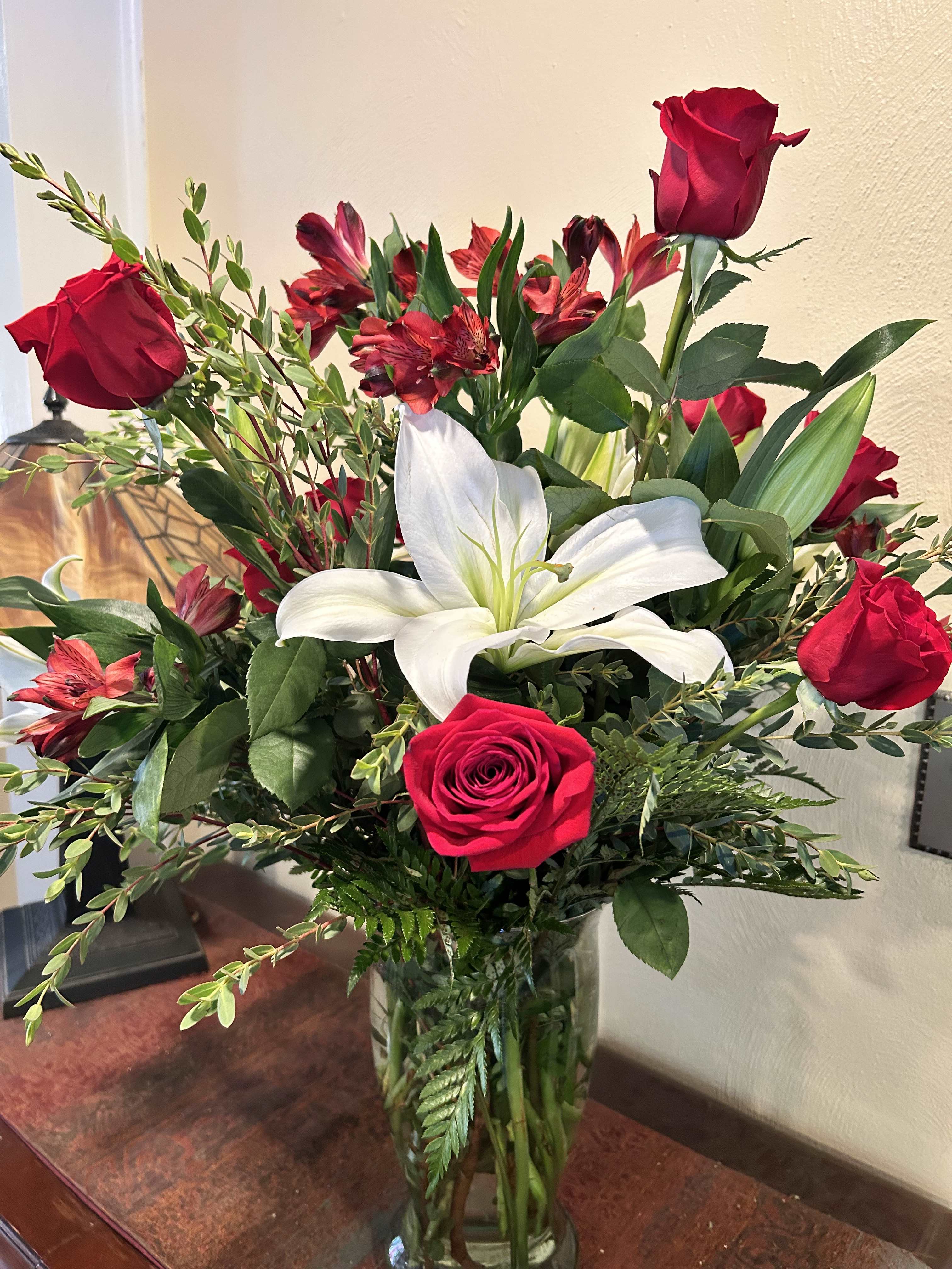 Bouquet of red roses and white lilies in a glass vase