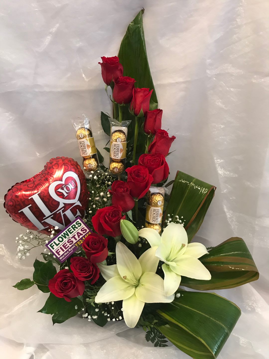 Red roses and white lilies with a heart balloon and chocolates