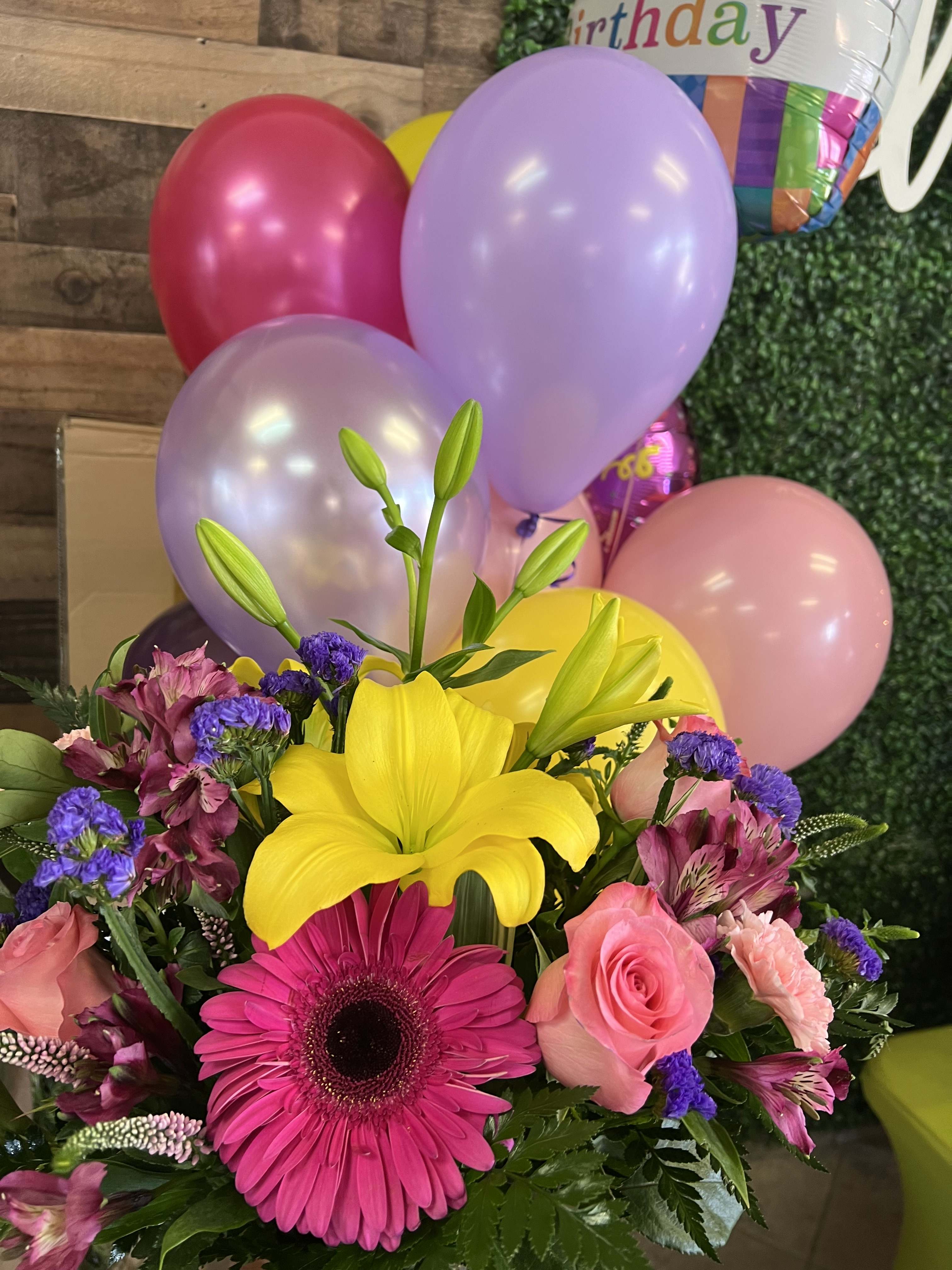 Bright mixed bouquet with yellow lily, pink gerbera, roses, and balloons