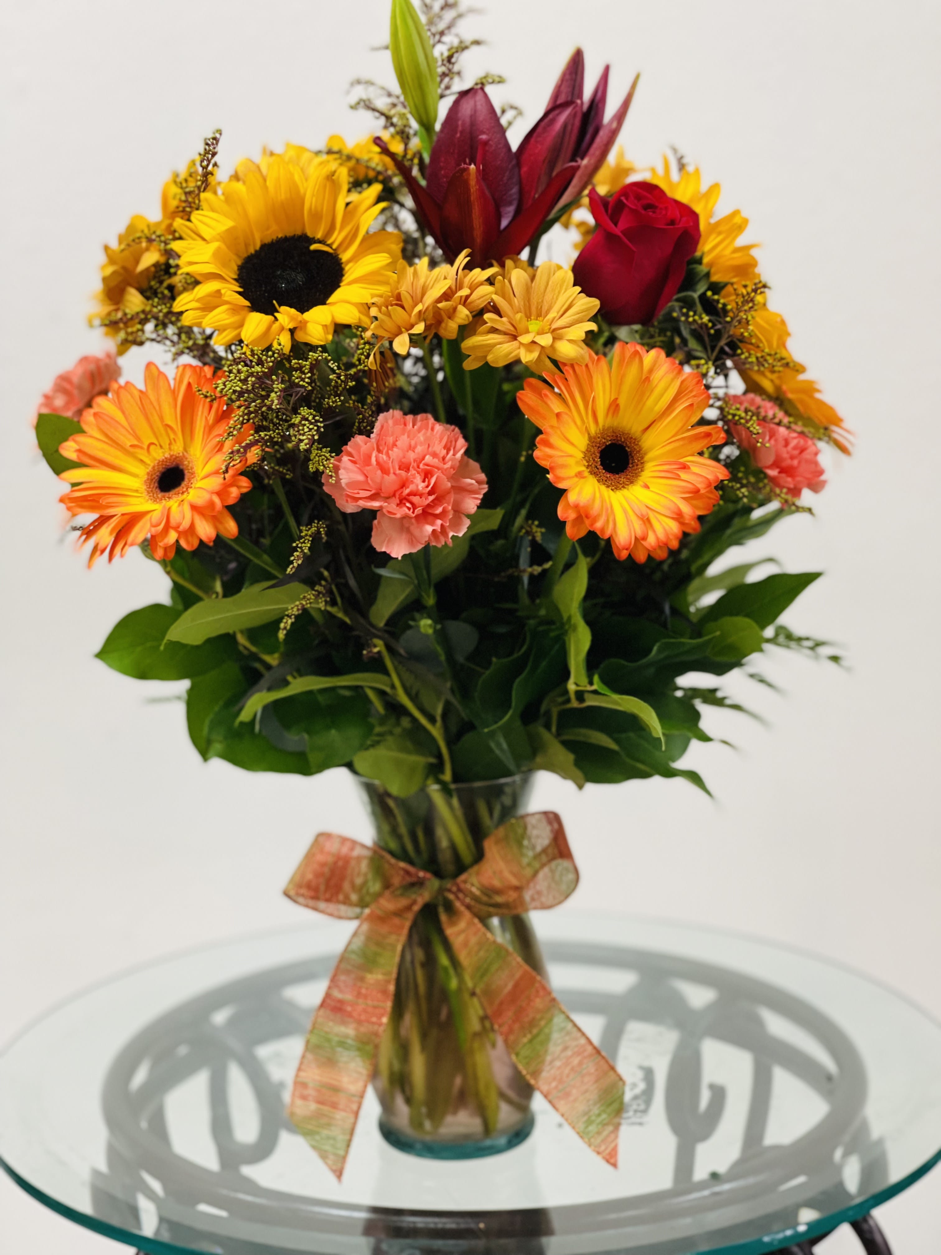 Bright mixed bouquet in a glass vase with a ribbon