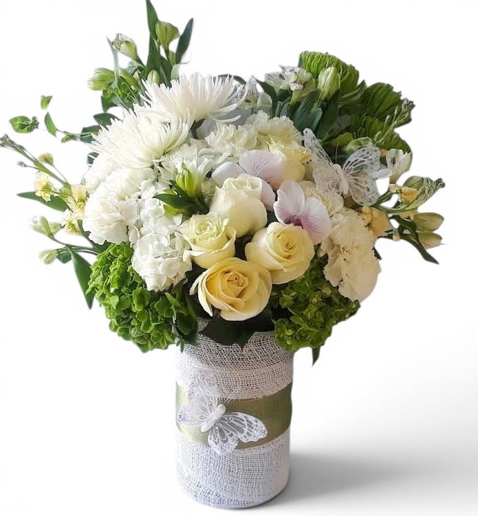 Vanilla Rose Bouquet Designer's Choice - This design is intended for home delivery only. Not for services. Designer's choice; made beautifully from my beautiful vanilla roses and orchids arranged in a tall modern glass cylinder vase wrapped in vanilla jute ribbon adorned with a beautiful butterfly. Stunning and perfect to send today to show them how much you care. All of my bouquets are always made extra special and unique each and every time. Send them happiness.
