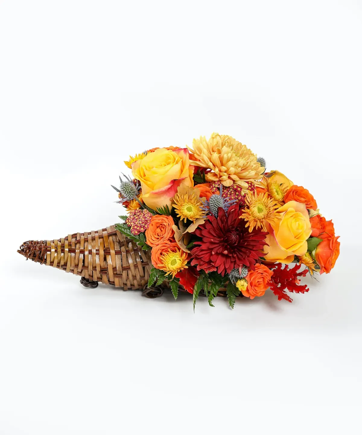 GOLDEN GATHERING CORNUCOPIA - This Golden Gathering Cornucopia is the perfect addition to any home or Thanksgiving dinner to embrace the Fall season. This cornucopia features bold and vibrant yellow, red, and orange blooms. You can use it as a centerpiece during your family gathering or gift it to those you can't be with for the holiday. Approximate Dimensions: 15" width x 9" height