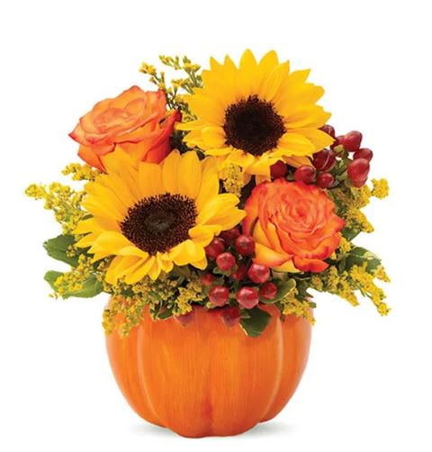 Sunflowers and orange roses arranged in a pumpkin-shaped vase