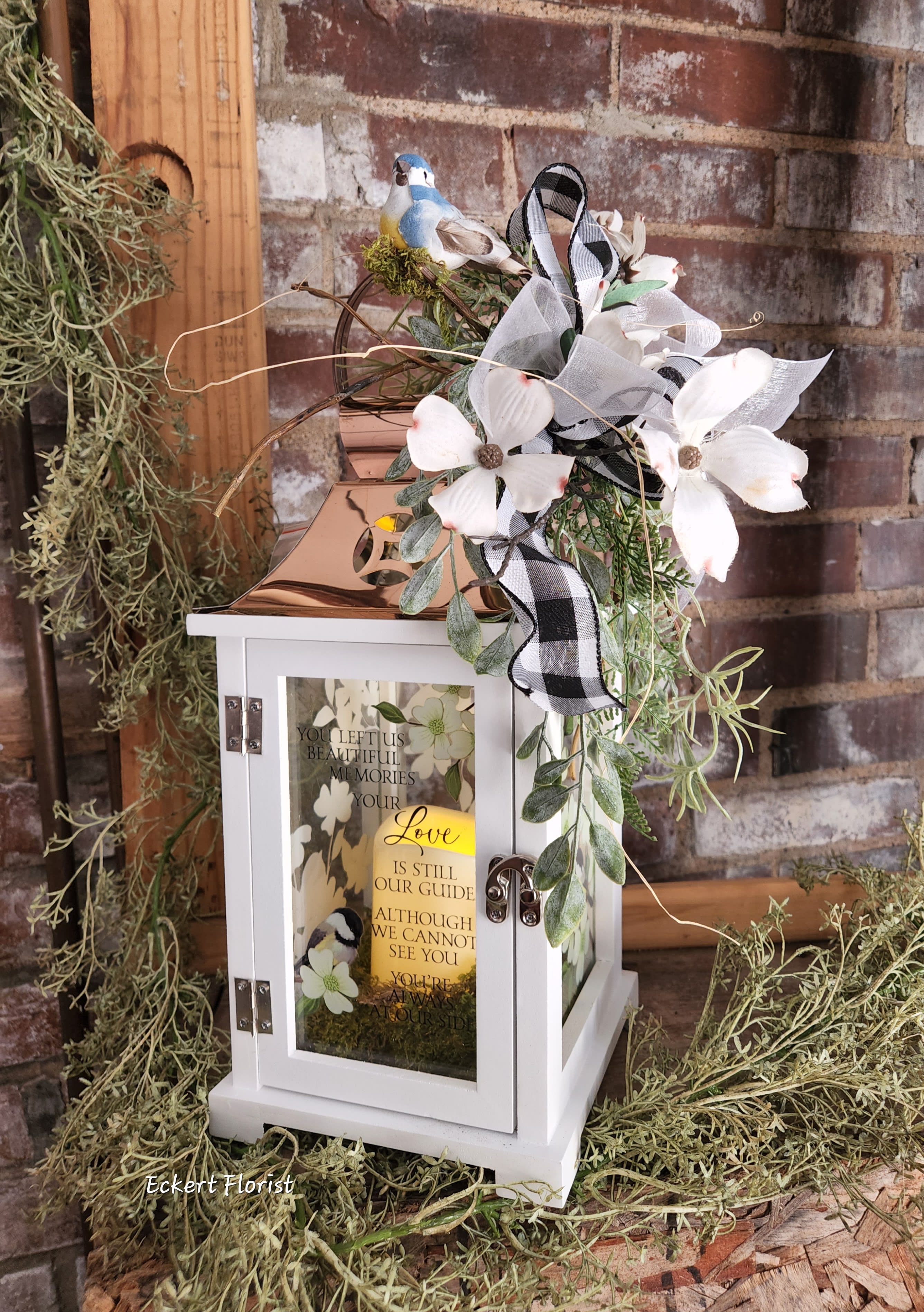 Eckert Florist's Beautiful Memories Lantern - Nice keepsake white wooden lantern with Copper tin roof and sentiment on Dogwood flower motif glass.  Sentiment: "You left us beautiful memories, your Love is still our guide. Although we cannot see you, you're always at our side." Included is a battery operated candle.  Measures approx. 6.25" Square x 15" High *OUR LOCAL DELIVERY ONLY