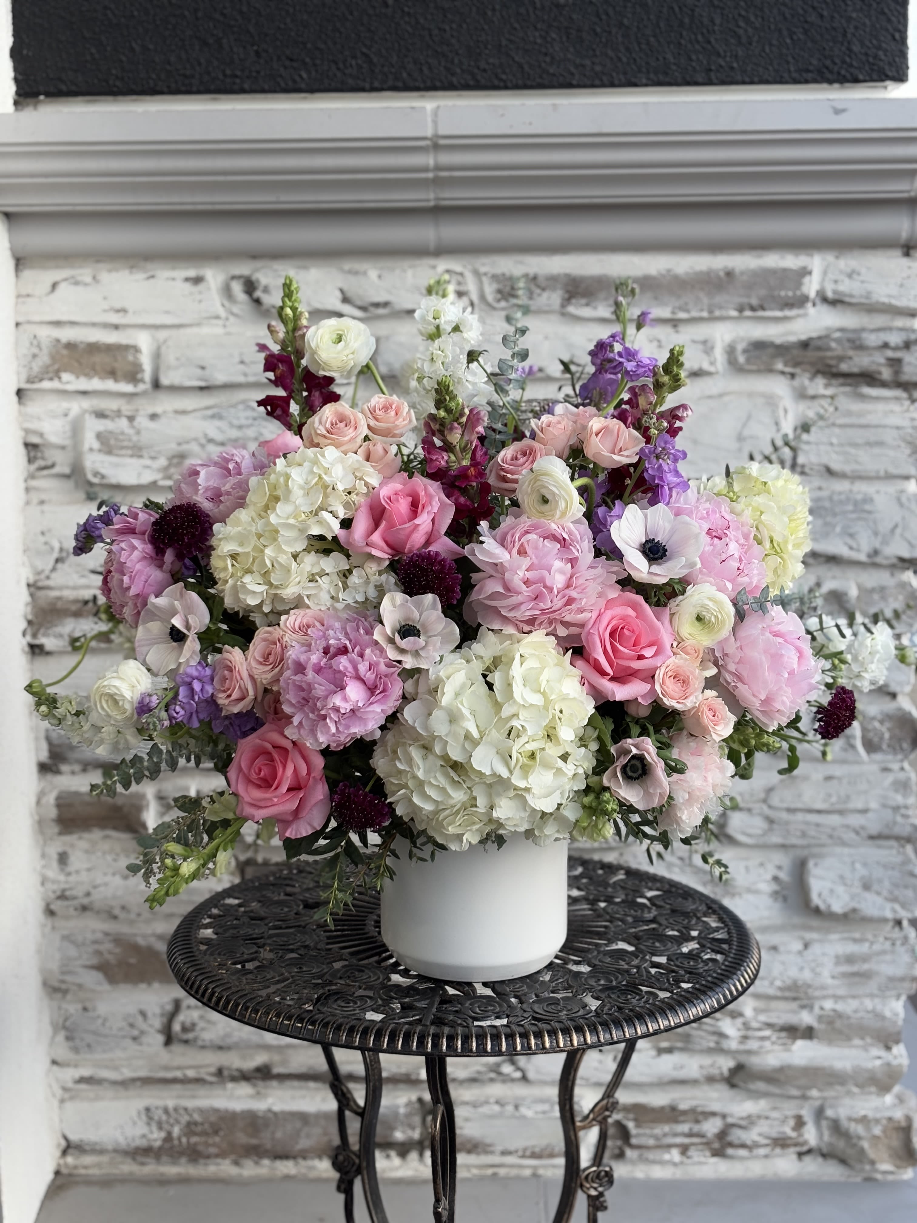 Pink and white mixed flower arrangement in a white vase