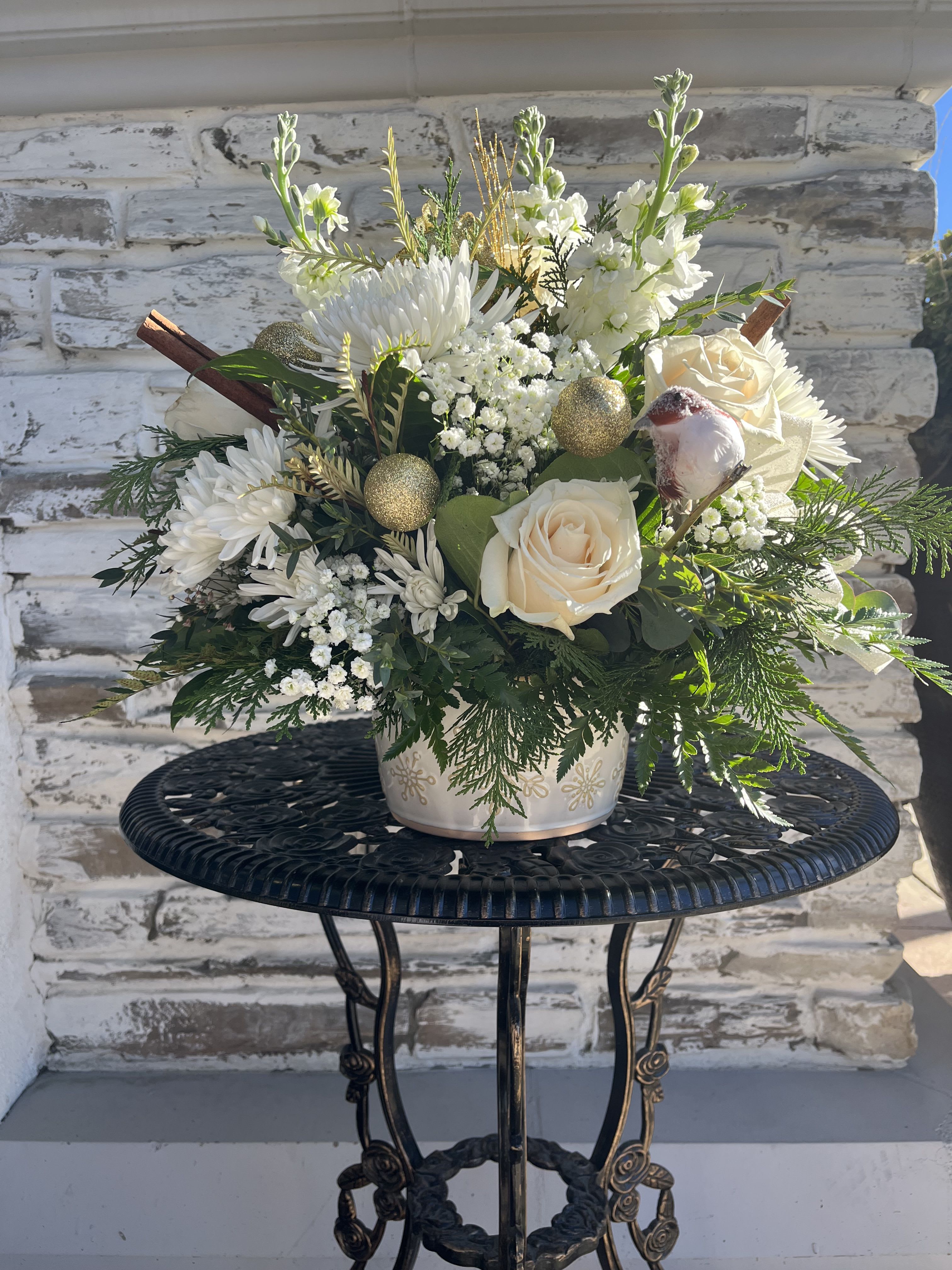 White floral arrangement with cream roses in a decorative pot