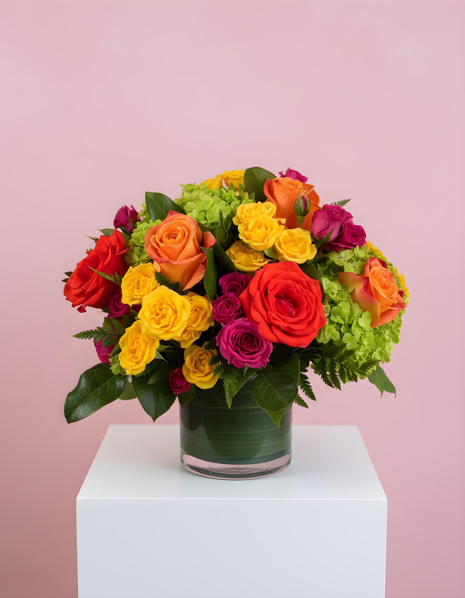 Summer Blooms  - Blow someone away with a bouquet that has so much style all it needs is its own runway.  Brilliant green hydrangeas, hot pink and bi-color roses, hot pink and yellow spray roses and greens are hand-delivered in stunning style: a 5x5 cylinder vase that's been elegantly lined with green leaf tape. This bouquet is a singular sensation!  Approximately 13" W x 12" H  
