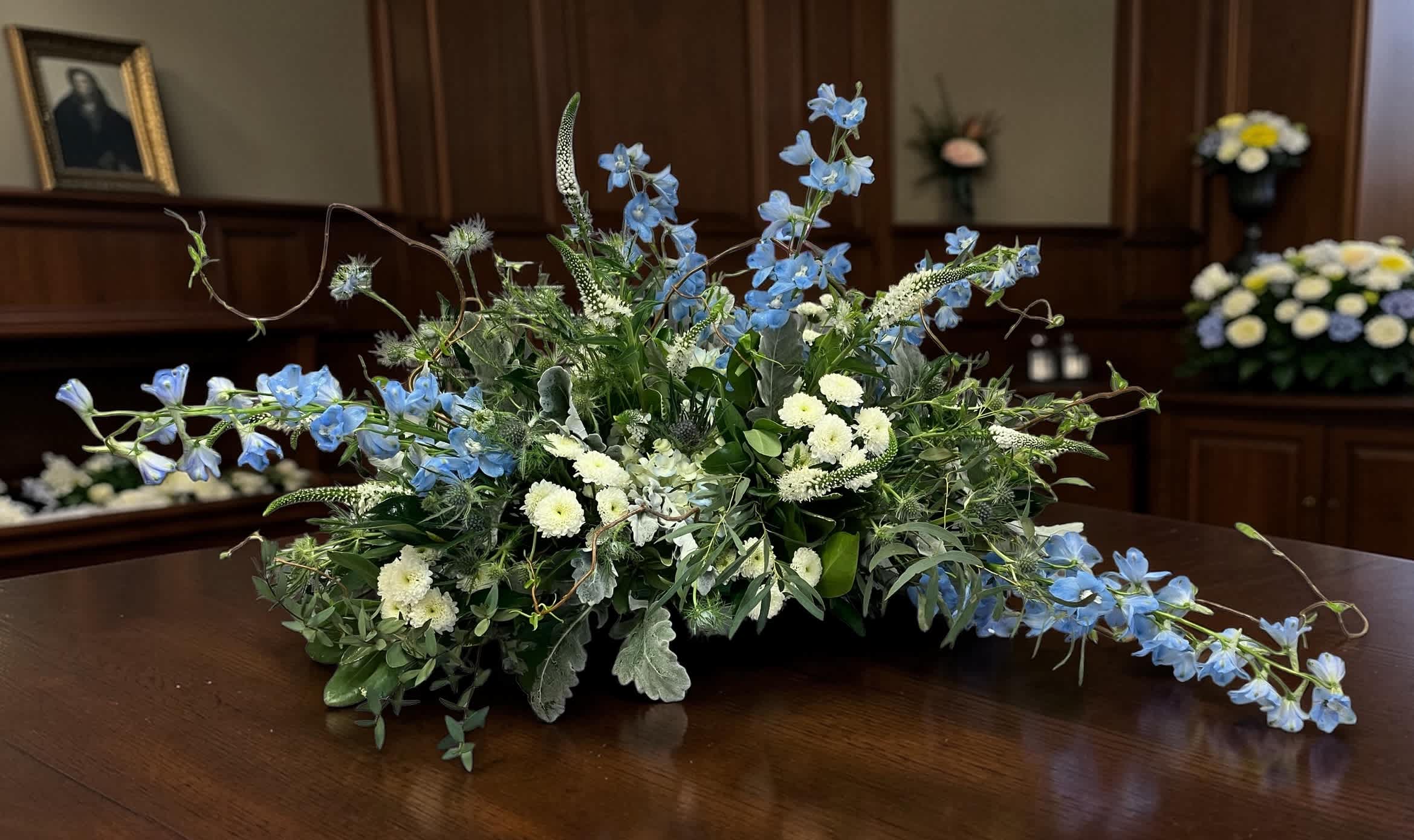Low floral arrangement with blue and white flowers on a table