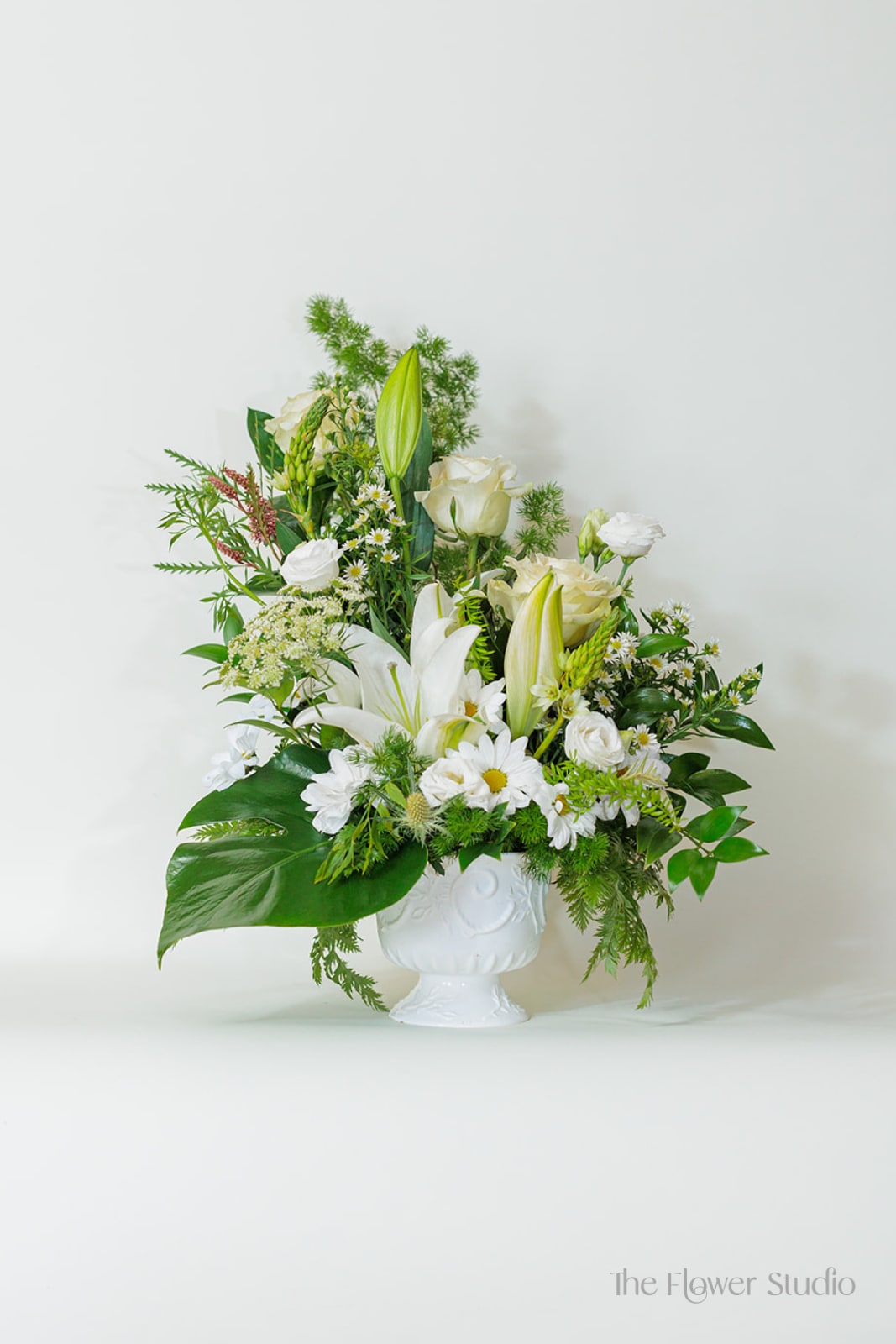 White floral arrangement in a white pedestal vase