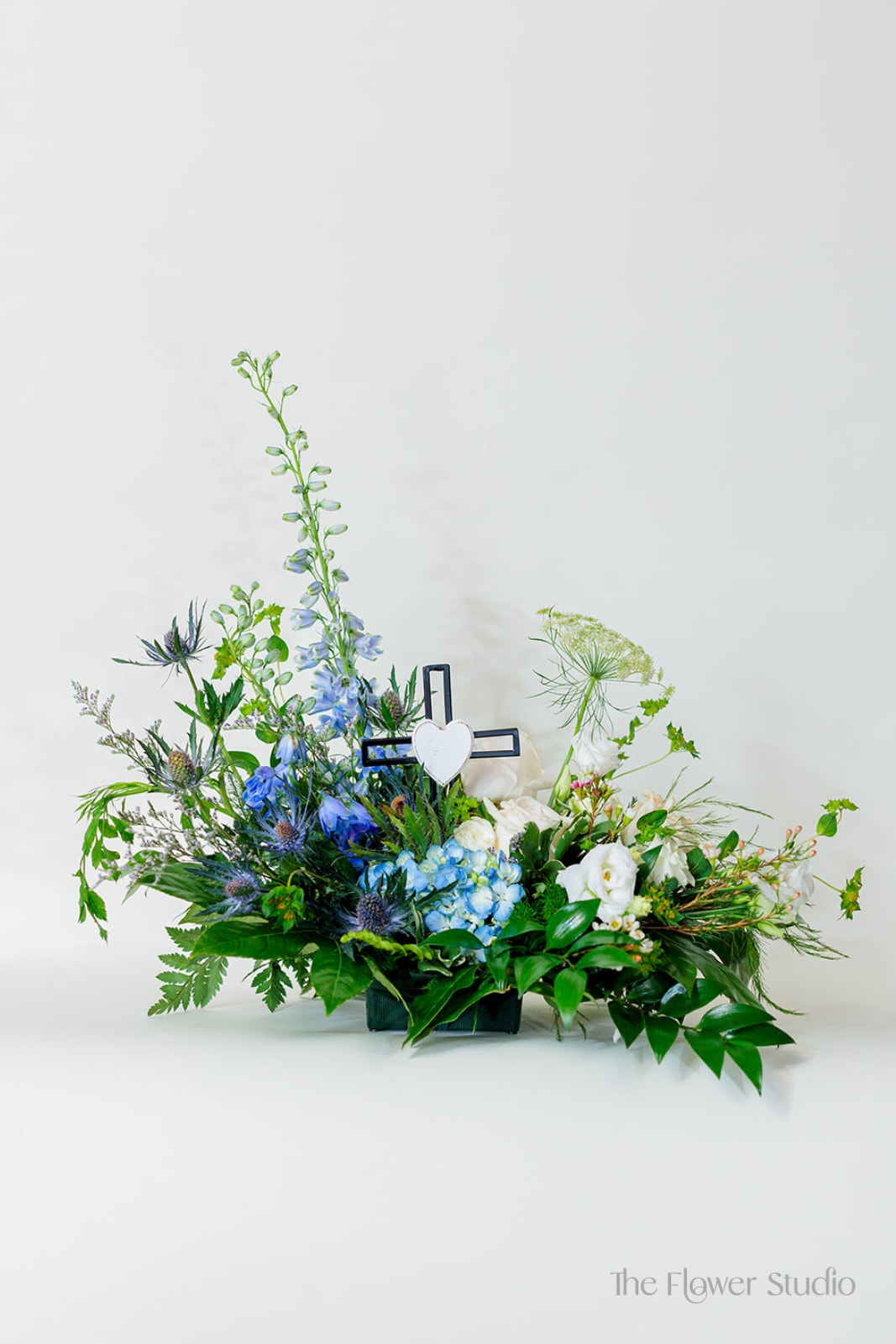 Blue and white floral arrangement with a cross centerpiece