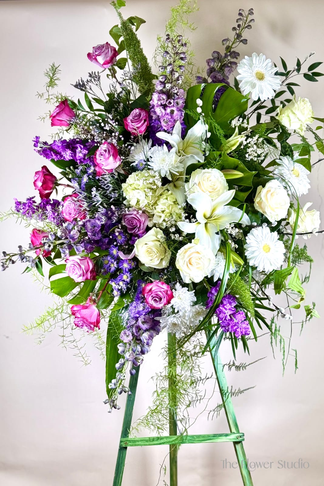 Tall mixed bouquet with pink and white roses, lilies, and purple flowers