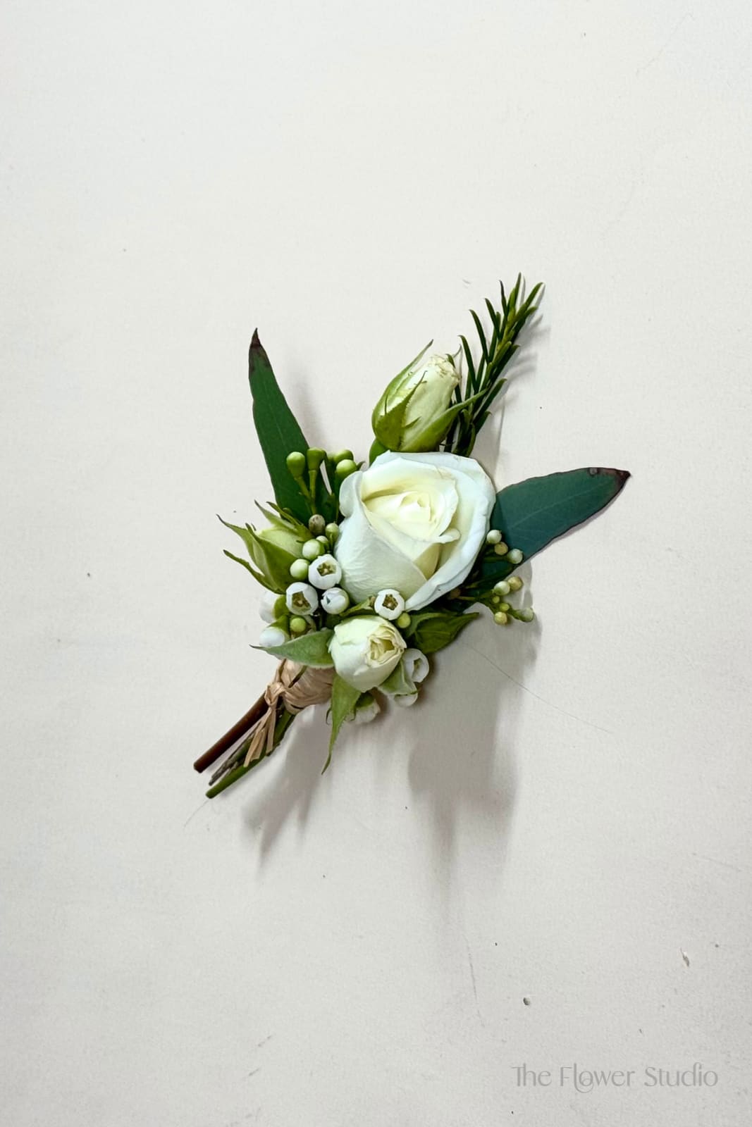 Small white rose boutonniere with green buds and leaves