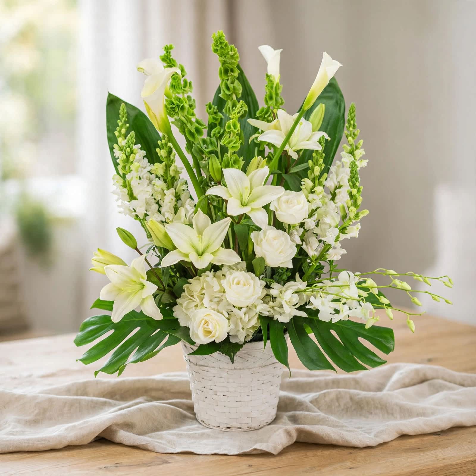 White lilies and roses arranged in a white woven basket
