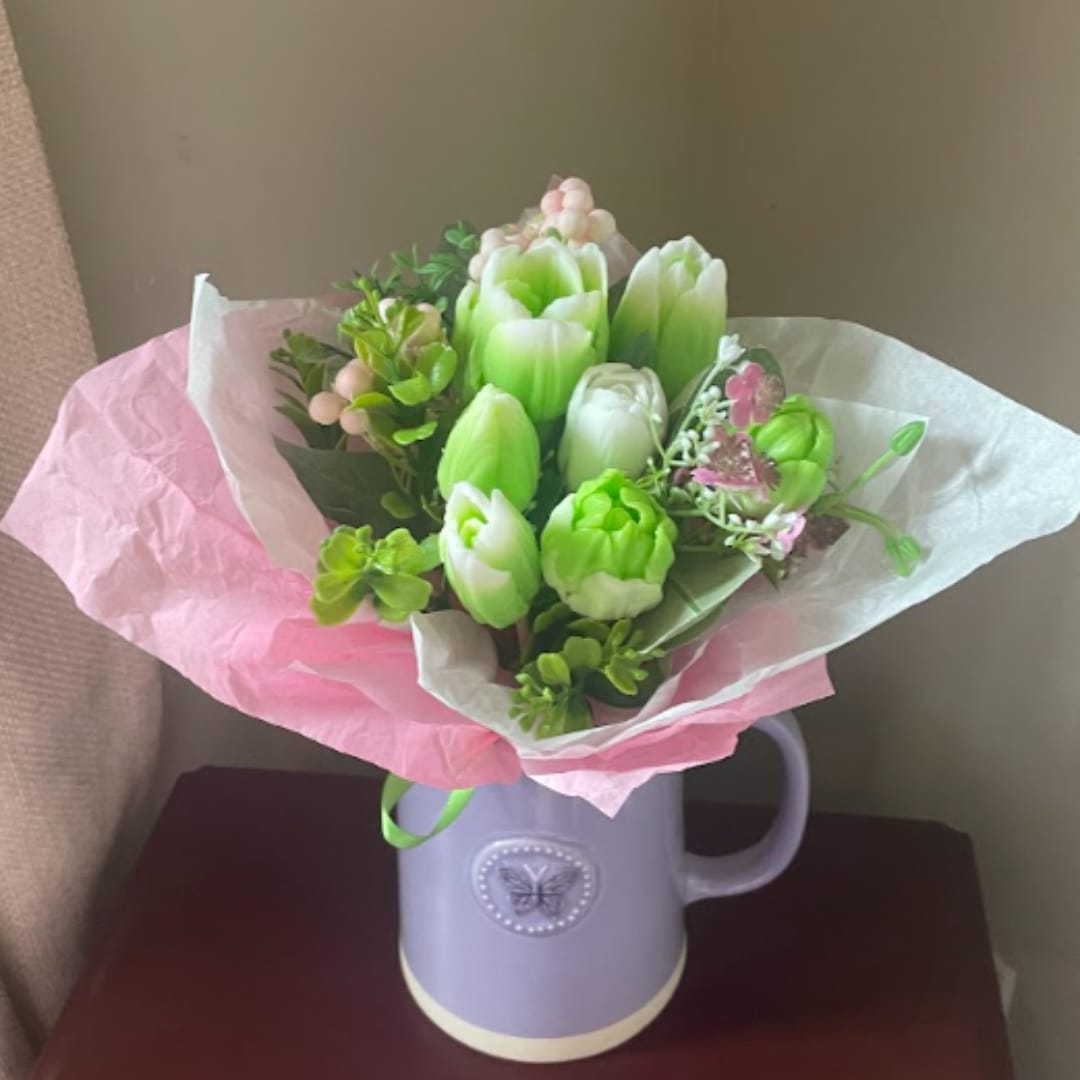 Bouquet of green and white tulips in a lavender mug vase