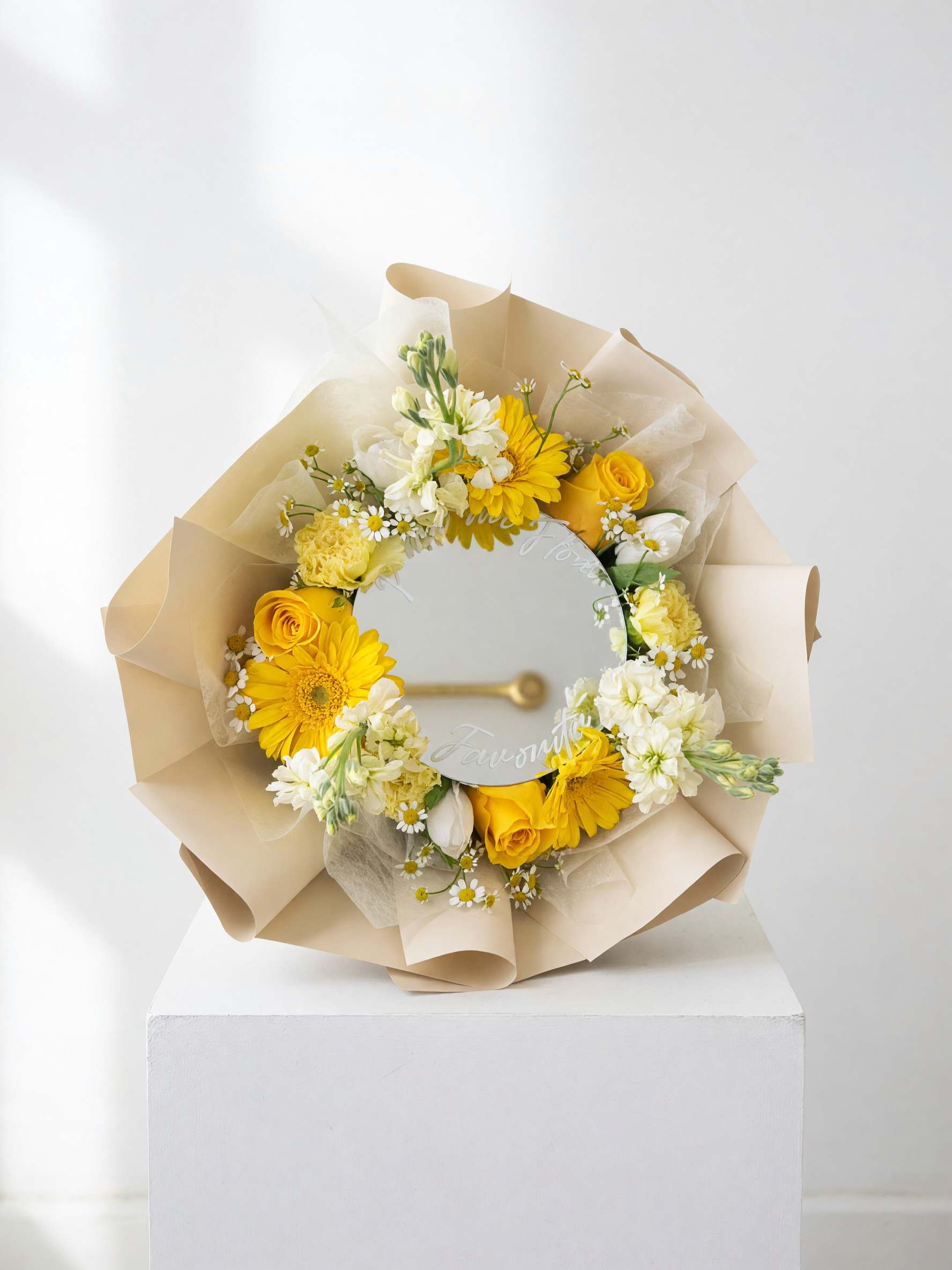 Yellow and white flower bouquet wrapped around a round mirror