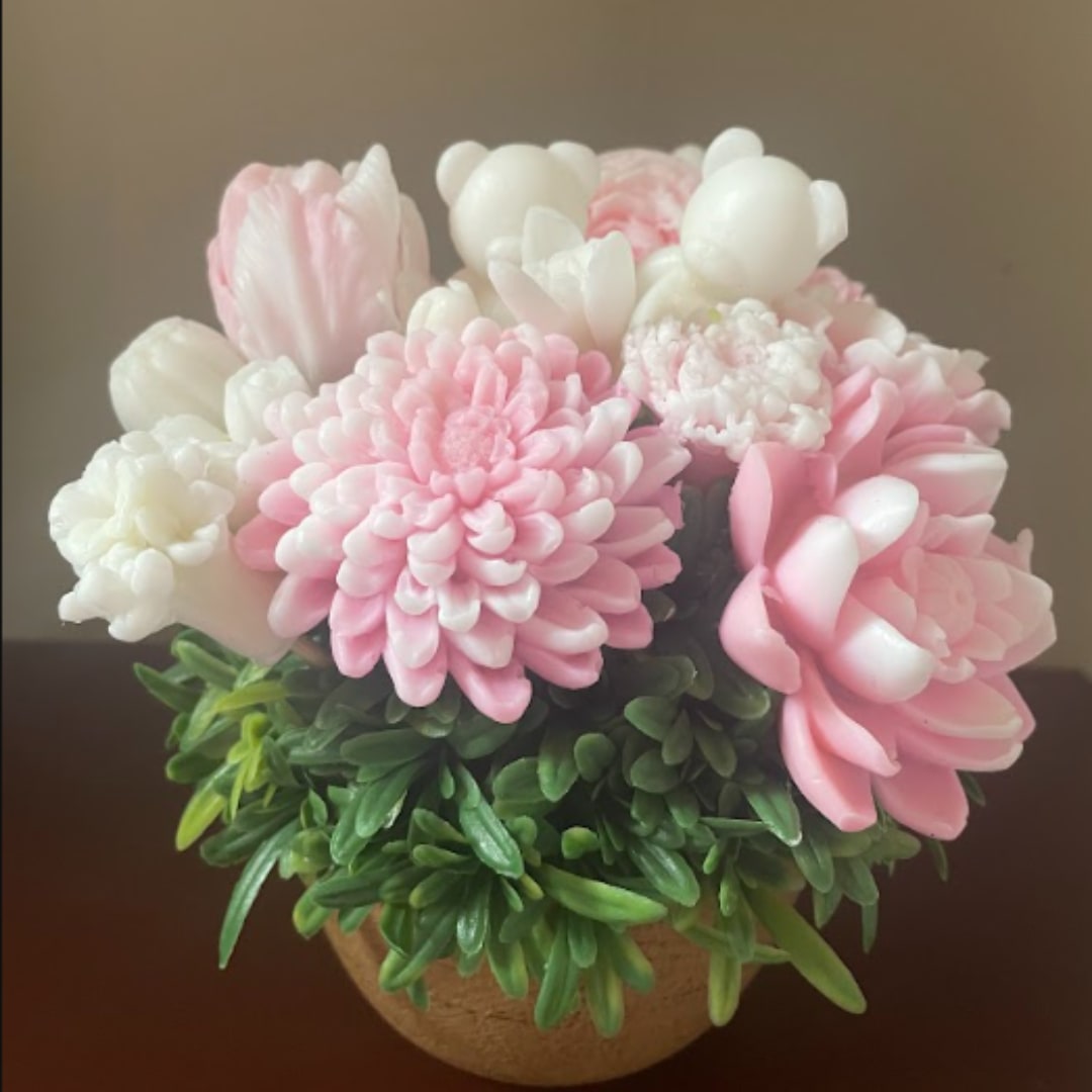Pink and white flower arrangement in a round pot